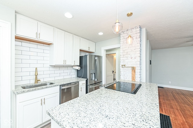 kitchen featuring sink, white cabinetry, tasteful backsplash, decorative light fixtures, and stainless steel appliances