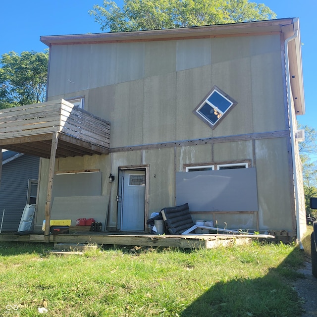 back of house with a wooden deck and a yard