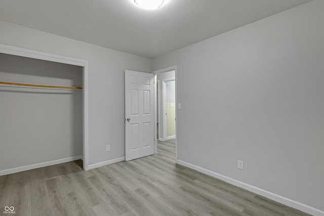 unfurnished bedroom featuring a closet and light wood-type flooring