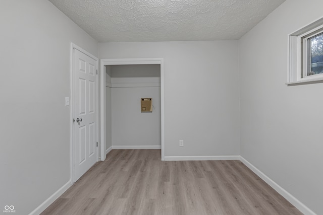 interior space featuring a textured ceiling and light wood-type flooring