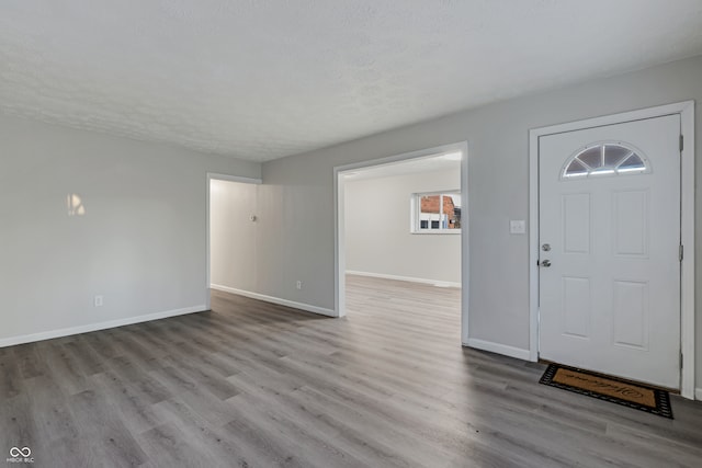 entrance foyer featuring a textured ceiling and light wood-type flooring