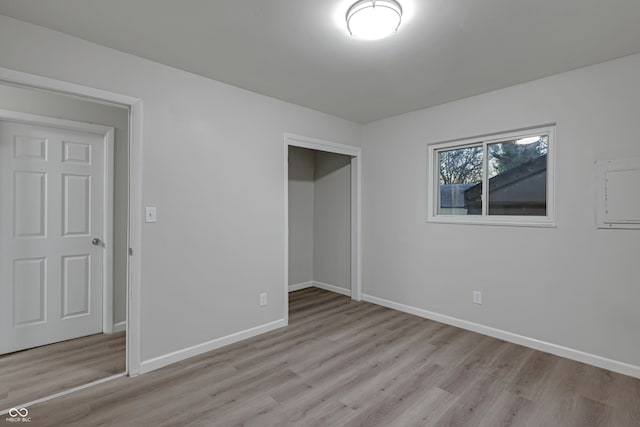 unfurnished bedroom with light wood-type flooring and a closet