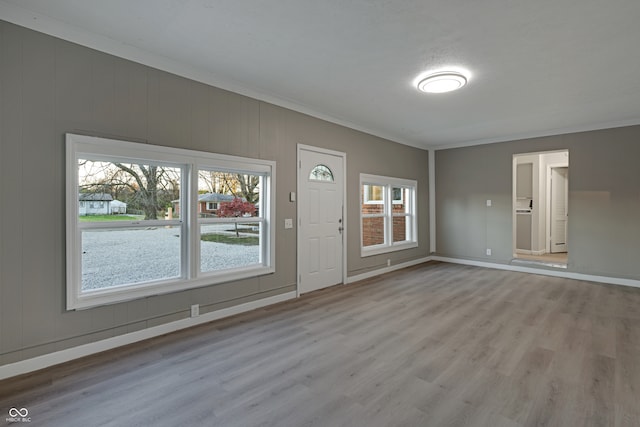 foyer featuring light hardwood / wood-style floors, plenty of natural light, and ornamental molding