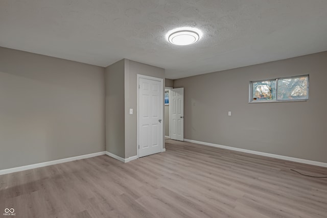 interior space featuring a textured ceiling and light wood-type flooring