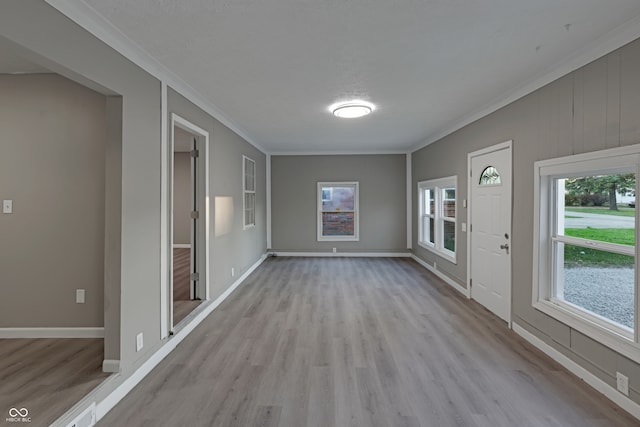 interior space featuring light hardwood / wood-style floors, a healthy amount of sunlight, and crown molding