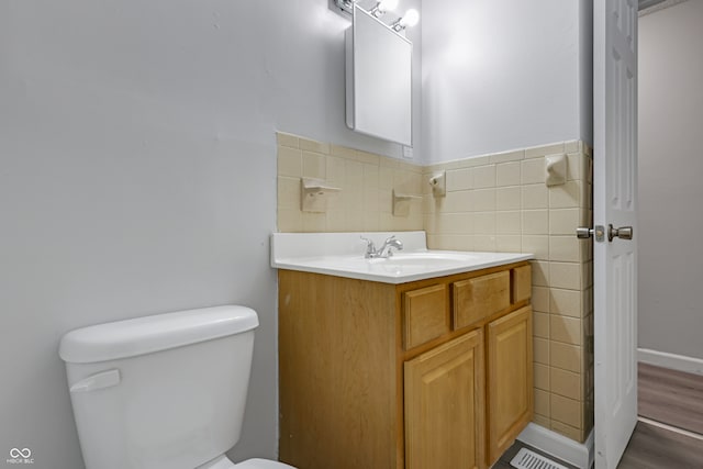 bathroom featuring hardwood / wood-style floors, vanity, toilet, and tile walls