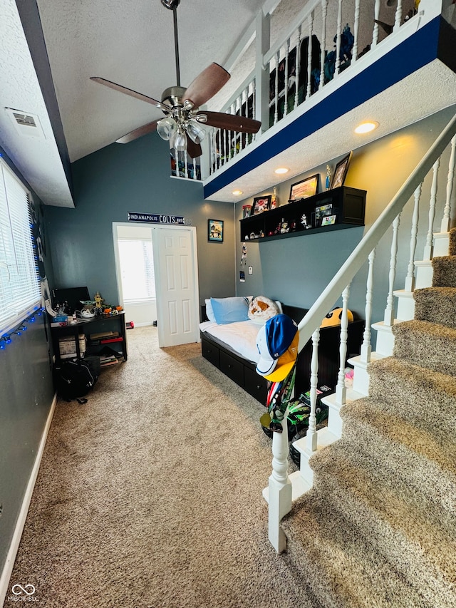 carpeted bedroom featuring a textured ceiling, ceiling fan, and vaulted ceiling