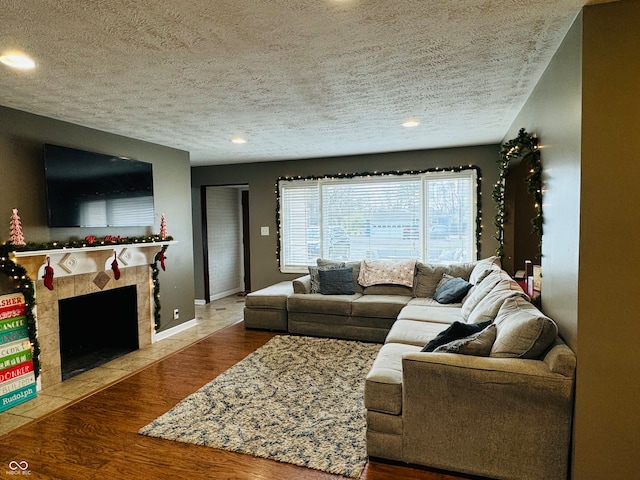 living room featuring a fireplace, a textured ceiling, and hardwood / wood-style flooring