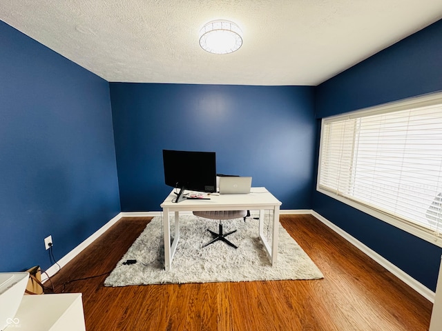 office area with hardwood / wood-style floors and a textured ceiling