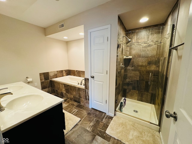 bathroom featuring vanity and independent shower and bath