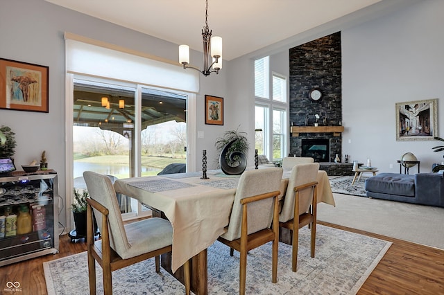 dining room featuring a fireplace, hardwood / wood-style flooring, and a chandelier