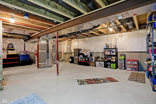 basement featuring gas water heater, electric panel, and heating unit