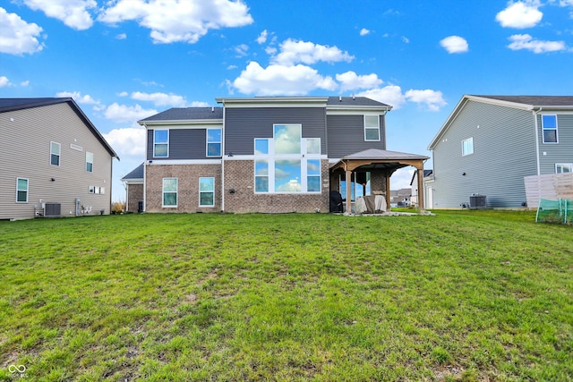 back of property featuring a gazebo, cooling unit, and a lawn