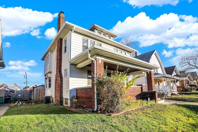 view of home's exterior with a lawn, a porch, and central AC unit