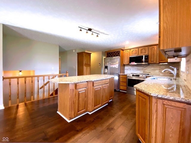 kitchen featuring sink, tasteful backsplash, a center island, appliances with stainless steel finishes, and dark hardwood / wood-style flooring