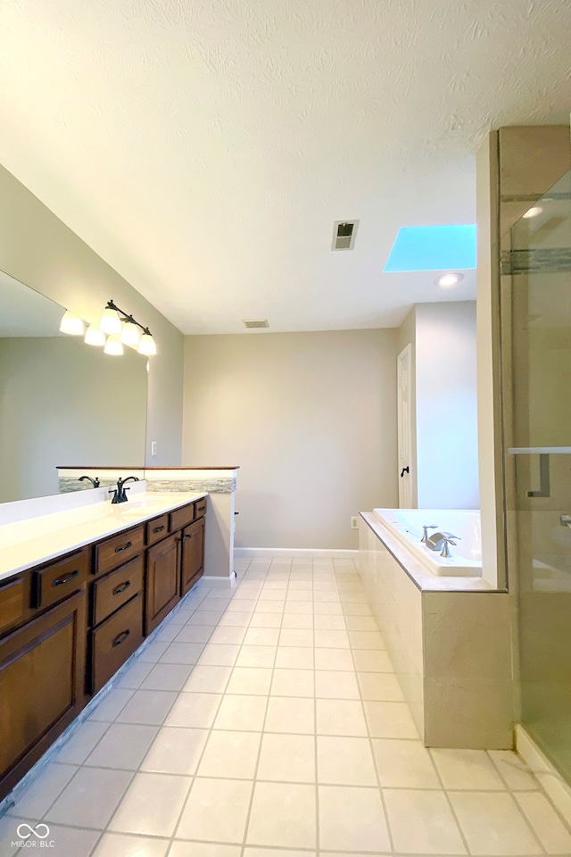 bathroom featuring tile patterned flooring, vanity, separate shower and tub, and a textured ceiling