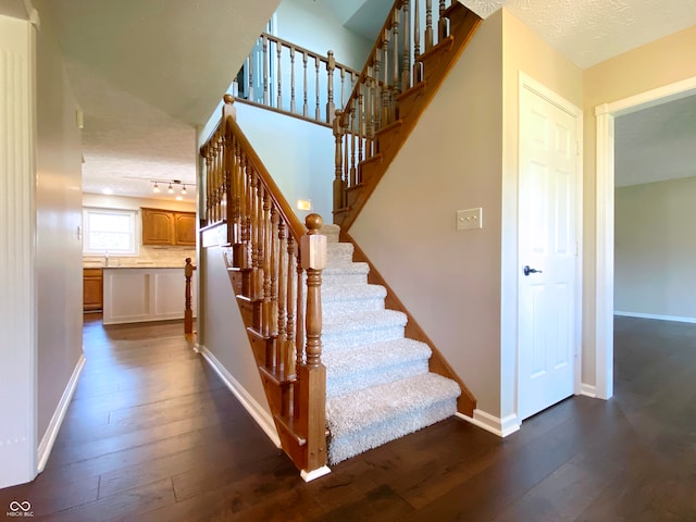 stairs with wood-type flooring and a textured ceiling