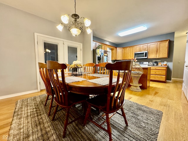 dining room featuring light hardwood / wood-style floors and a chandelier