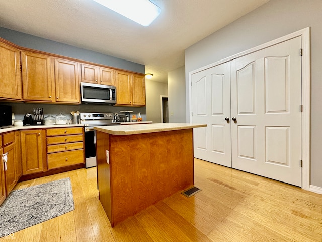 kitchen featuring a kitchen island, light hardwood / wood-style floors, and appliances with stainless steel finishes