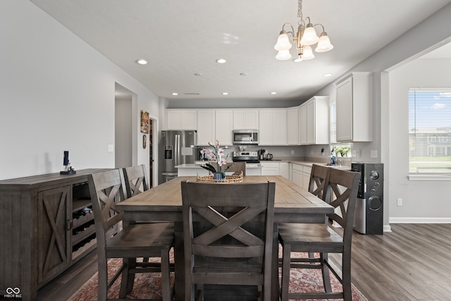 dining area featuring wood-type flooring and a notable chandelier