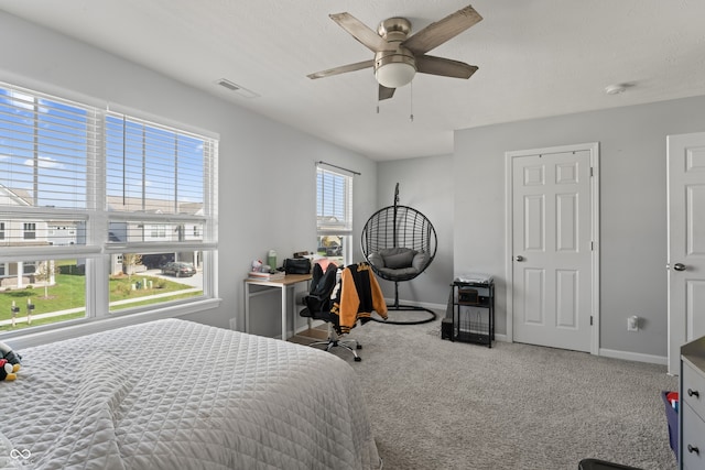 bedroom featuring light carpet, a textured ceiling, and ceiling fan