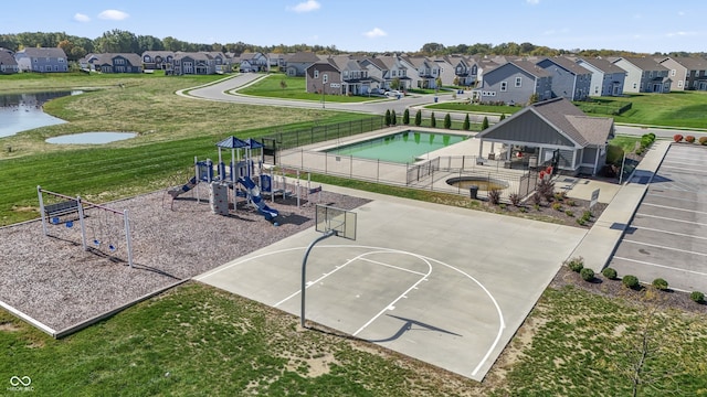 view of sport court featuring a playground and a water view