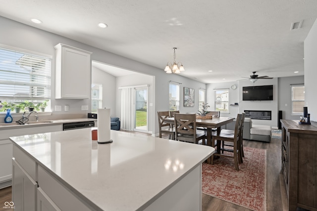 kitchen with white cabinets, a healthy amount of sunlight, a kitchen island, and pendant lighting