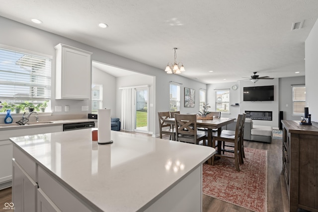 10797 Walden Ln, Brownsburg, IN 46112 - kitchen featuring dark wood-style flooring, a sink, a glass covered fireplace, recessed lighting, and a ceiling fan