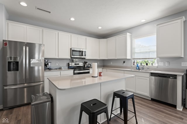 kitchen with sink, dark wood-type flooring, a textured ceiling, white cabinets, and appliances with stainless steel finishes