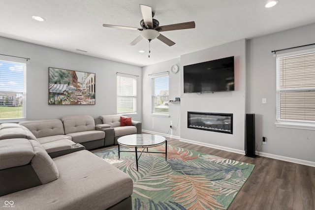 living room featuring ceiling fan, dark hardwood / wood-style flooring, and a textured ceiling