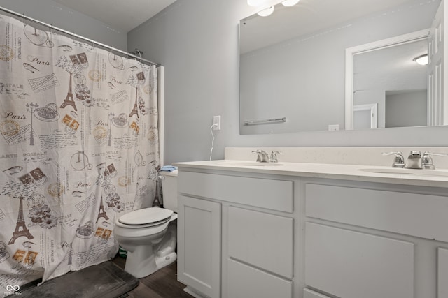 bathroom featuring hardwood / wood-style floors, vanity, toilet, and walk in shower