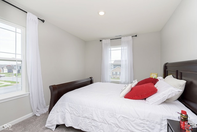 carpeted bedroom featuring multiple windows