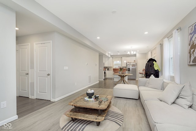 living room featuring a chandelier and light hardwood / wood-style flooring