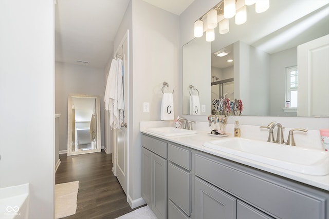 bathroom with hardwood / wood-style floors, vanity, and an enclosed shower