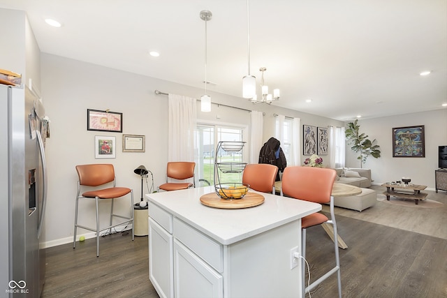 kitchen featuring decorative light fixtures, stainless steel fridge with ice dispenser, a center island, dark hardwood / wood-style floors, and white cabinetry