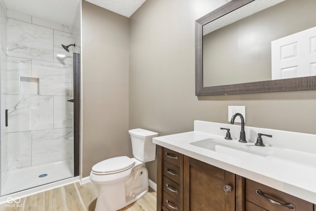 bathroom featuring toilet, a shower with door, vanity, and hardwood / wood-style flooring