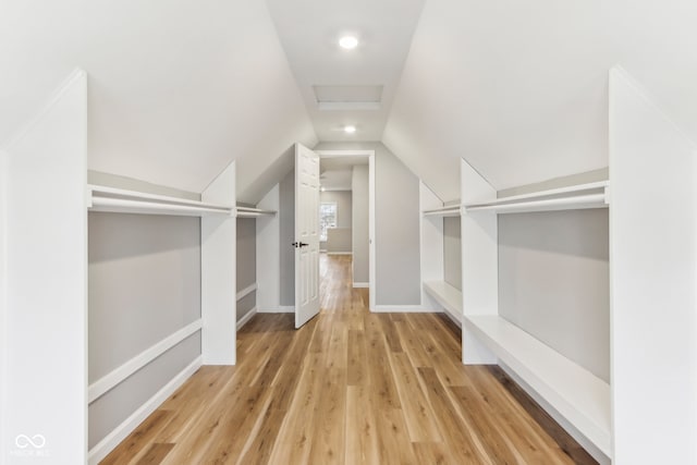 spacious closet featuring lofted ceiling and light wood-type flooring