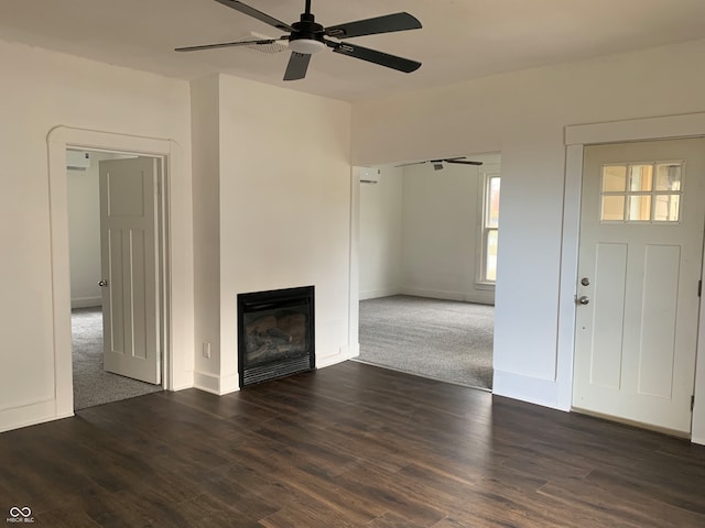 unfurnished living room featuring ceiling fan and dark wood-type flooring