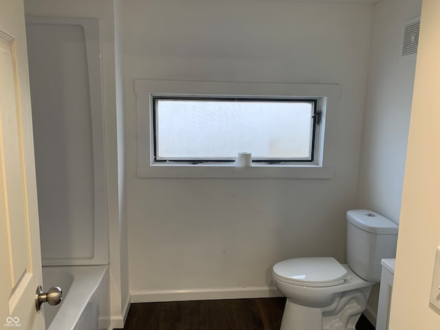 bathroom featuring a tub, toilet, vanity, and hardwood / wood-style flooring