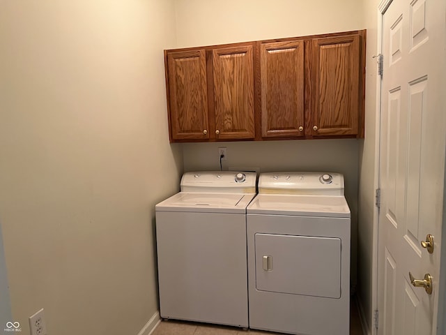 laundry area featuring washer and clothes dryer and cabinets