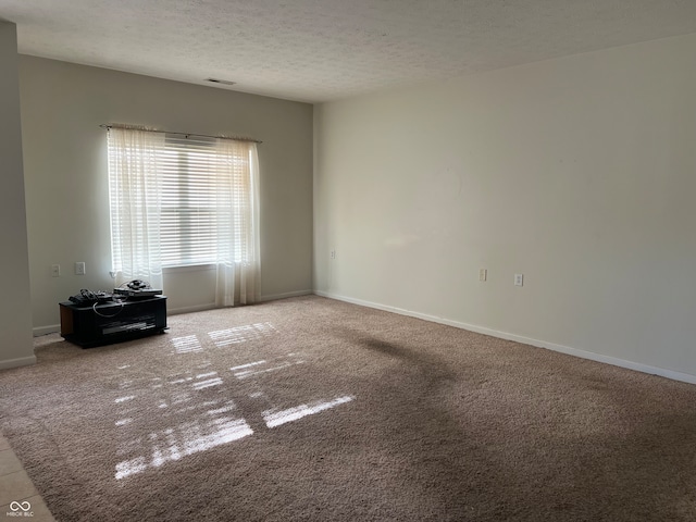 carpeted spare room featuring a textured ceiling