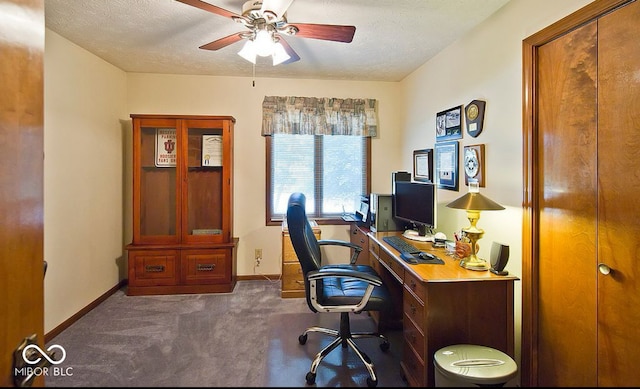 office space with a textured ceiling, dark carpet, and ceiling fan