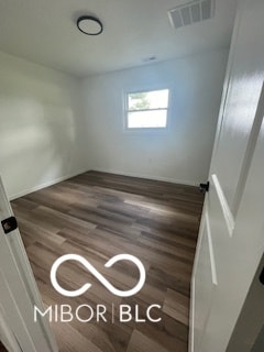 unfurnished room with dark wood-type flooring