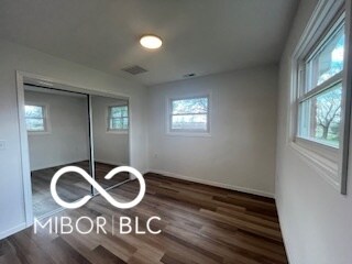 unfurnished bedroom featuring a closet and dark wood-type flooring