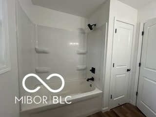 bathroom featuring tub / shower combination and hardwood / wood-style flooring