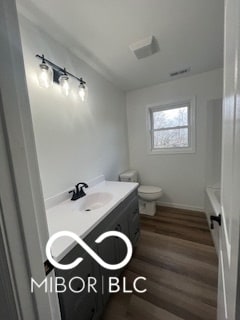 bathroom featuring wood-type flooring, vanity, and toilet