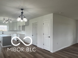 kitchen featuring dark hardwood / wood-style flooring, an inviting chandelier, and hanging light fixtures