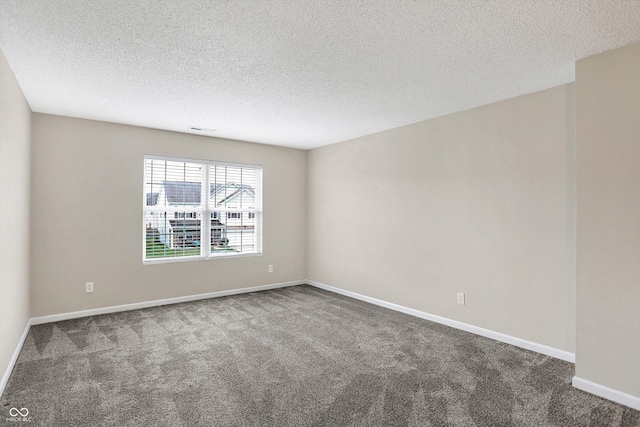 empty room with carpet and a textured ceiling