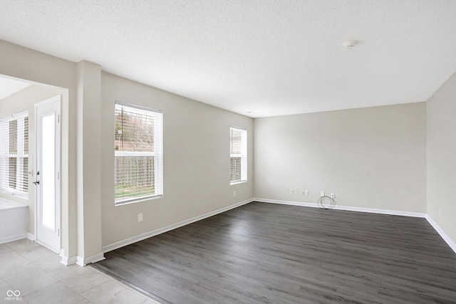 empty room with wood-type flooring and a textured ceiling