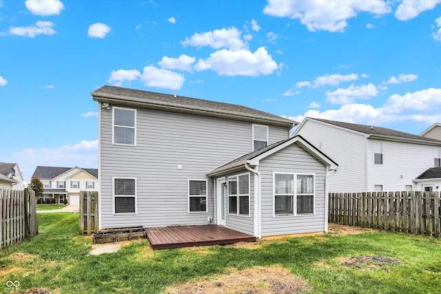 rear view of house with a yard and a wooden deck